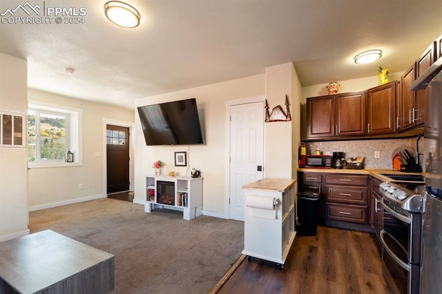 kitchen with electric stove, a fireplace, decorative backsplash, and dark hardwood / wood-style floors