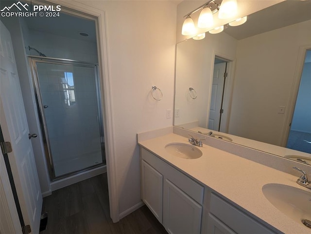 bathroom featuring vanity, wood-type flooring, and an enclosed shower