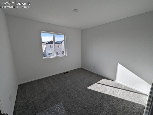 empty room with dark colored carpet