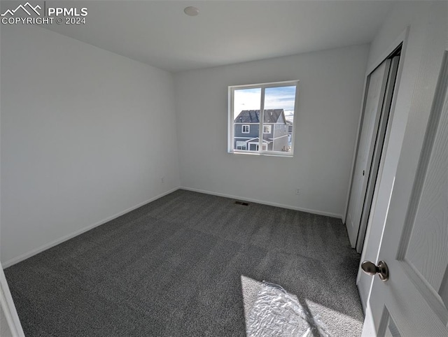 unfurnished bedroom with dark carpet