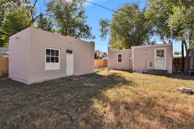 rear view of house featuring a yard