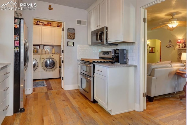 kitchen featuring appliances with stainless steel finishes, white cabinetry, and independent washer and dryer