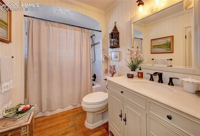 full bathroom with shower / bath combination with curtain, hardwood / wood-style flooring, ornamental molding, vanity, and toilet