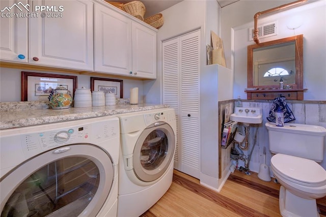 laundry room with sink, light wood-type flooring, and washer and dryer