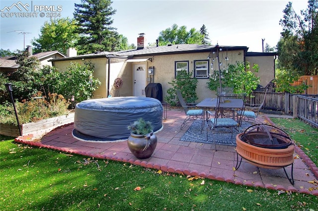 exterior space with a lawn, an outdoor fire pit, and a patio area