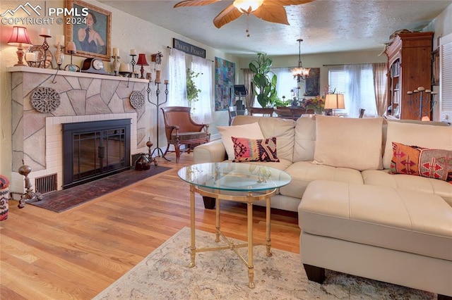 living room with ceiling fan with notable chandelier and hardwood / wood-style flooring