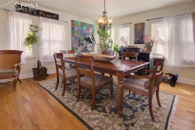 dining room featuring light wood-type flooring and a chandelier