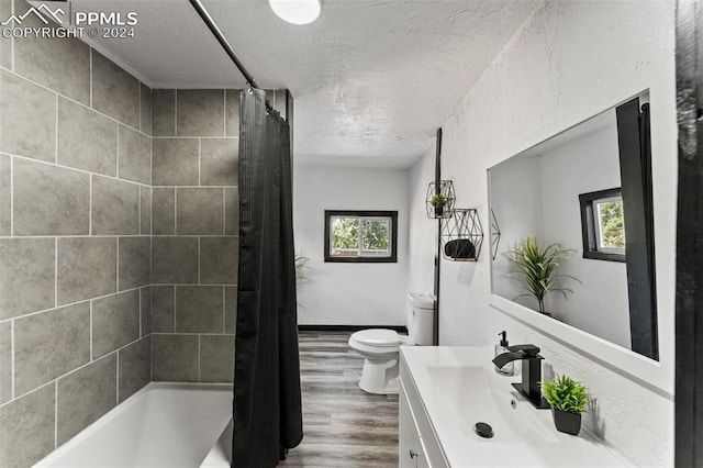 full bathroom featuring wood-type flooring, vanity, shower / bath combo with shower curtain, and toilet