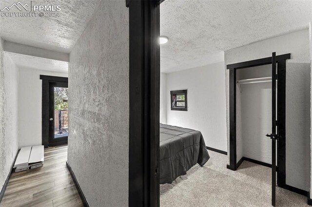 bedroom with a textured ceiling and light hardwood / wood-style floors