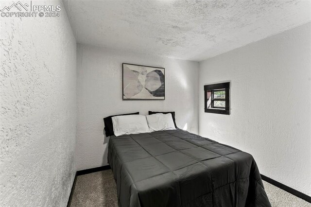 bedroom with a textured ceiling and carpet