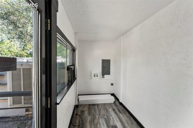 hallway featuring electric panel, dark hardwood / wood-style floors, and a textured ceiling