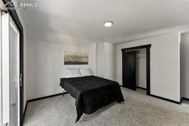 bedroom featuring a textured ceiling, light carpet, and a closet