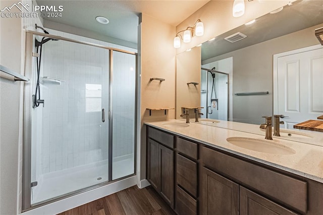 bathroom featuring hardwood / wood-style floors, vanity, and an enclosed shower