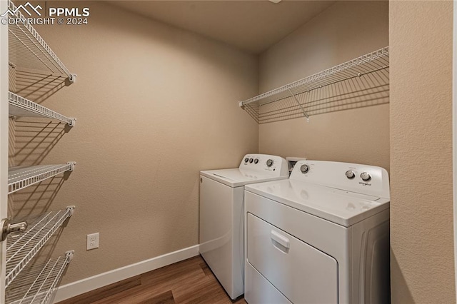 laundry area featuring washing machine and clothes dryer and wood-type flooring