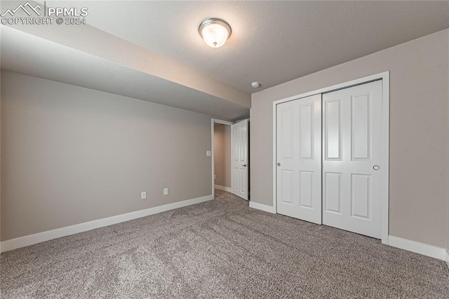 unfurnished bedroom featuring carpet and a closet