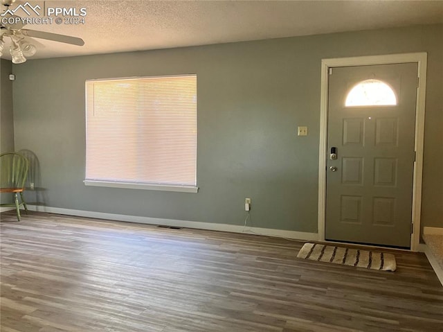 foyer entrance with hardwood / wood-style flooring, ceiling fan, and a textured ceiling