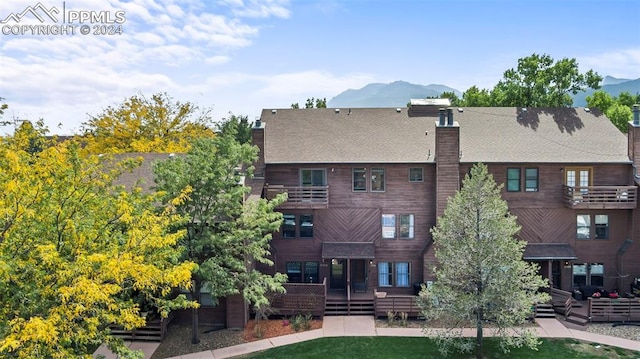 back of house featuring a lawn and a mountain view