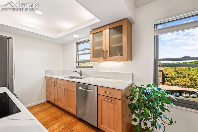 kitchen featuring sink, a healthy amount of sunlight, light stone counters, and appliances with stainless steel finishes