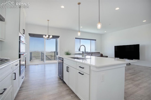 kitchen with a center island with sink, white cabinetry, and plenty of natural light