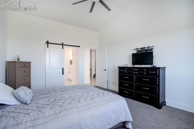 bedroom with ceiling fan, carpet flooring, a barn door, and high vaulted ceiling