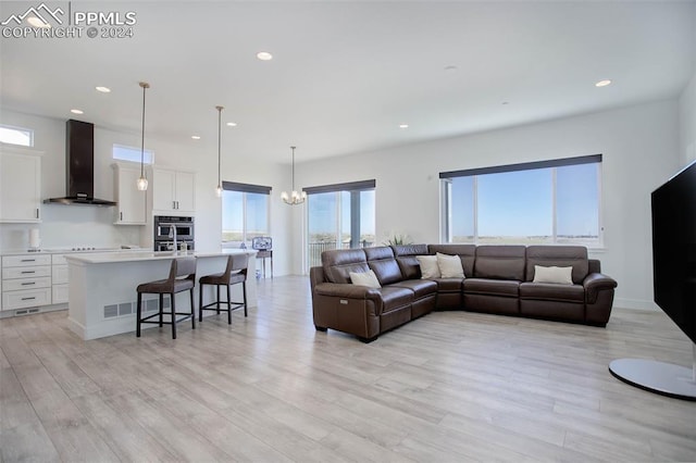 living room featuring a notable chandelier and light wood-type flooring