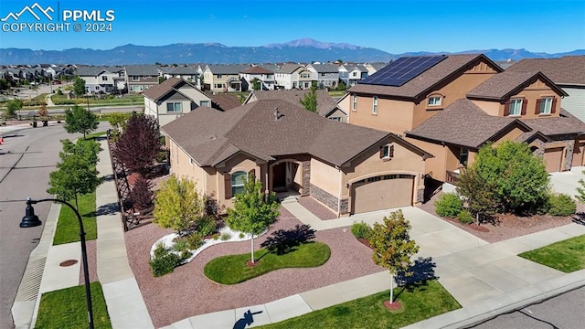 exterior space with solar panels, a mountain view, and a garage