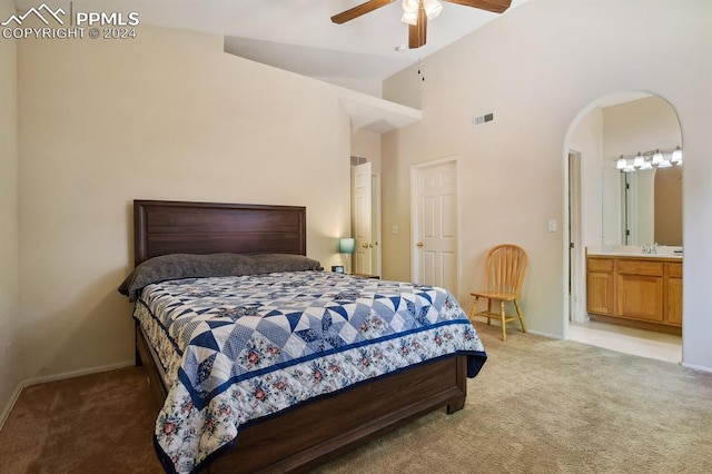 carpeted bedroom featuring ensuite bath, ceiling fan, sink, and high vaulted ceiling