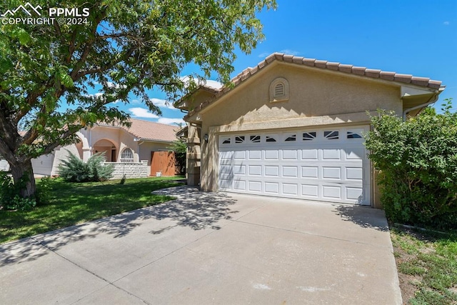 view of front of property with a front lawn and a garage