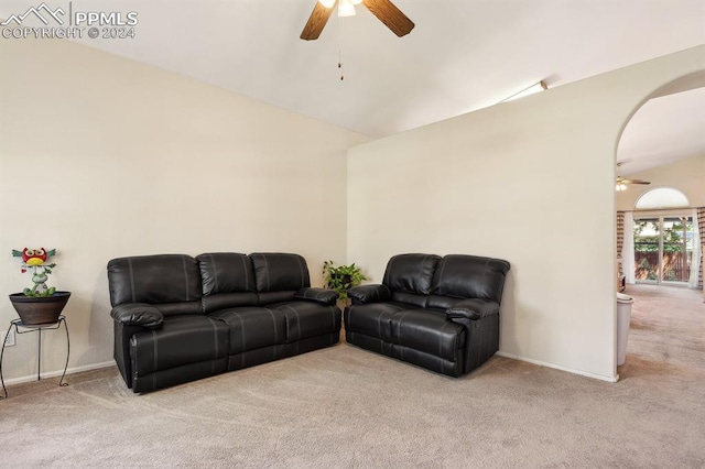 living room with lofted ceiling, ceiling fan, and light colored carpet