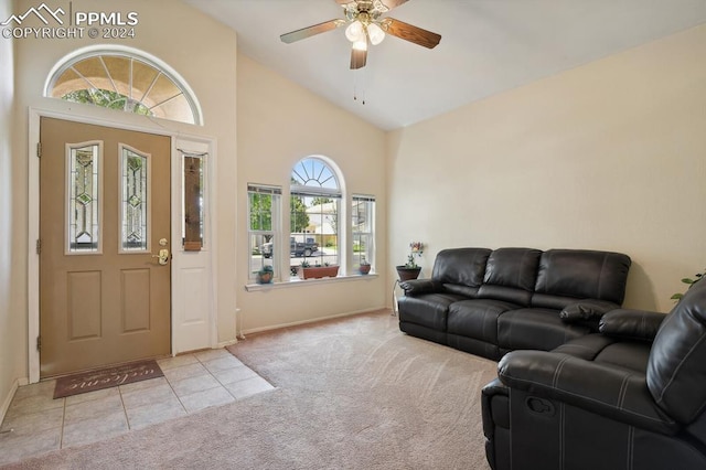 carpeted foyer entrance featuring high vaulted ceiling and ceiling fan