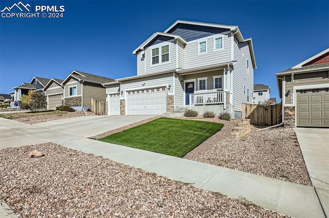 view of front of home with a garage, a front lawn, and a porch