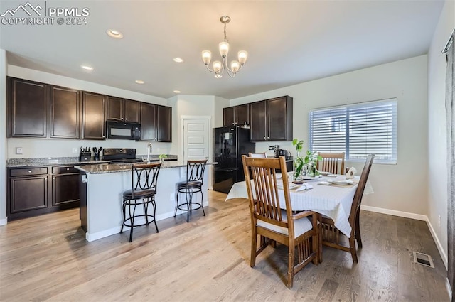 dining room featuring light hardwood / wood-style floors, an inviting chandelier, and sink