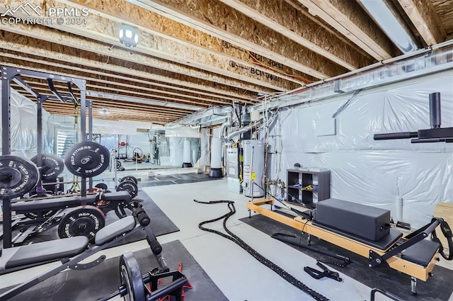 exercise area featuring gas water heater and concrete floors