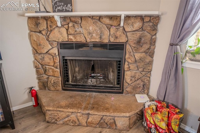 interior details with hardwood / wood-style floors and a stone fireplace