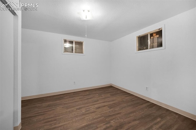 basement with dark hardwood / wood-style flooring