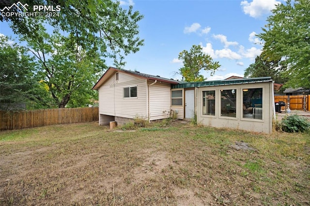 back of property featuring a lawn