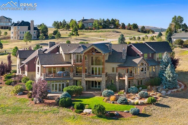 19155 Lochmere Ct, Monument, CO 80132 - rear view of house featuring stone siding and a balcony