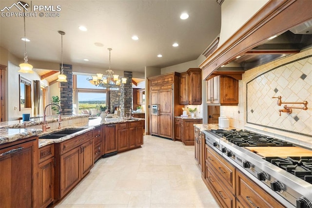 kitchen featuring stainless steel gas cooktop, backsplash, decorative light fixtures, light stone counters, and an inviting chandelier