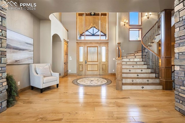 19155 Lochmere Ct, Monument, CO 80132 - entryway featuring wood-type flooring, stairway, a towering ceiling, arched walkways, and baseboards