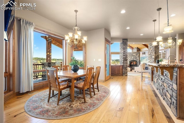 dining room with sink, a chandelier, and light hardwood / wood-style flooring