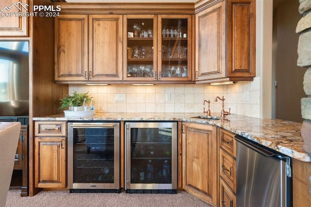 bar featuring wine cooler, light carpet, light stone countertops, and sink