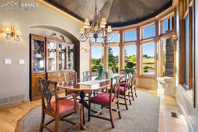 dining space with crown molding and light wood-type flooring