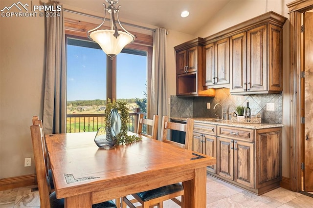 dining area with lofted ceiling, sink, and light tile patterned floors