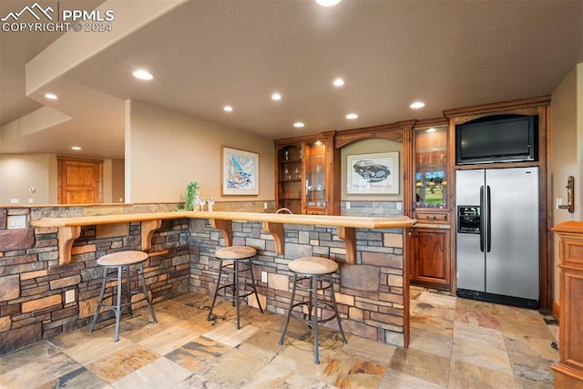 19155 Lochmere Ct, Monument, CO 80132 - indoor wet bar featuring stainless steel fridge with ice dispenser, stone tile floors, and recessed lighting