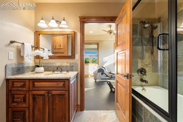 bathroom featuring vanity, combined bath / shower with glass door, and ceiling fan