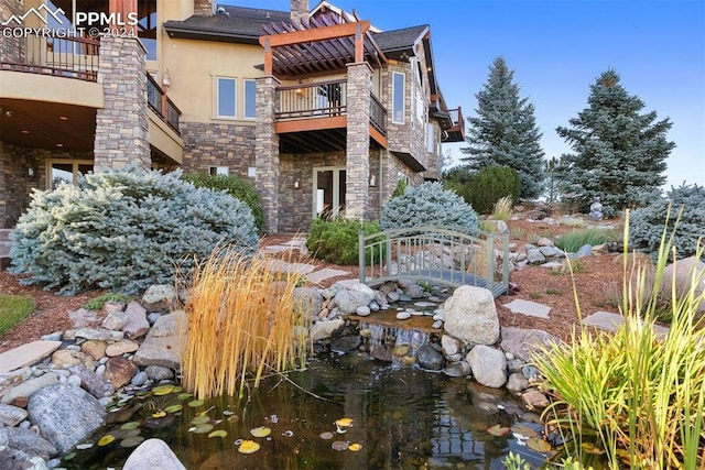 exterior space with a balcony and a small pond