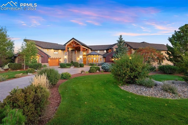 craftsman-style home with a garage and a lawn