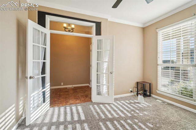 spare room with carpet, crown molding, ceiling fan, and french doors