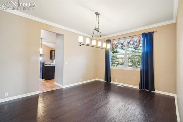 empty room with ornamental molding, a chandelier, and hardwood / wood-style floors