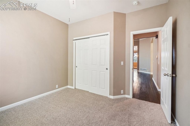 unfurnished bedroom featuring ceiling fan, a closet, and hardwood / wood-style floors